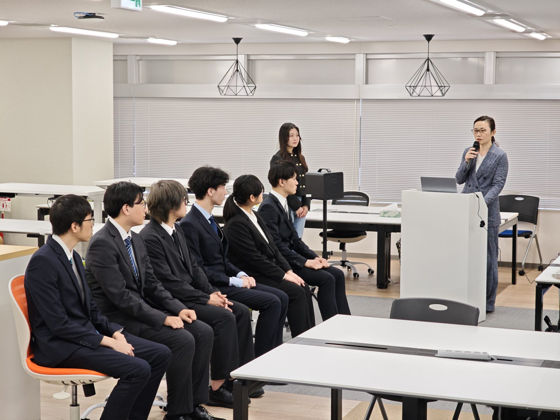 挨拶する弊社代表と、それを聞く新人